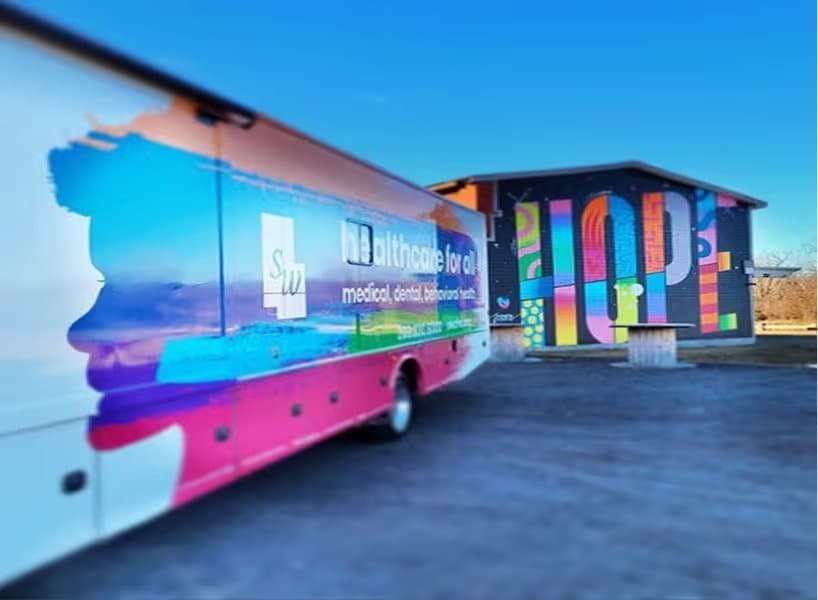 A brightly liveried mobile clinic parked on site
