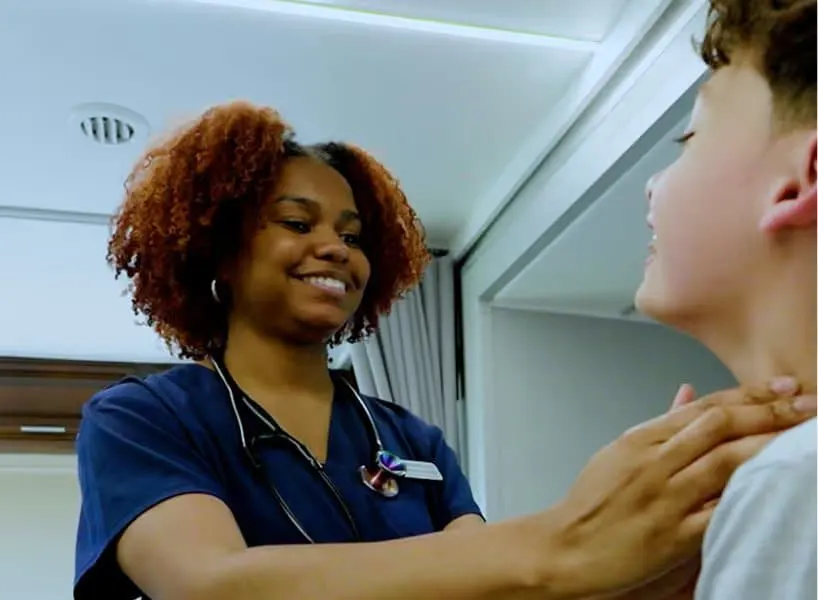 A clinician seeing a young patient inside a mobile clinic
